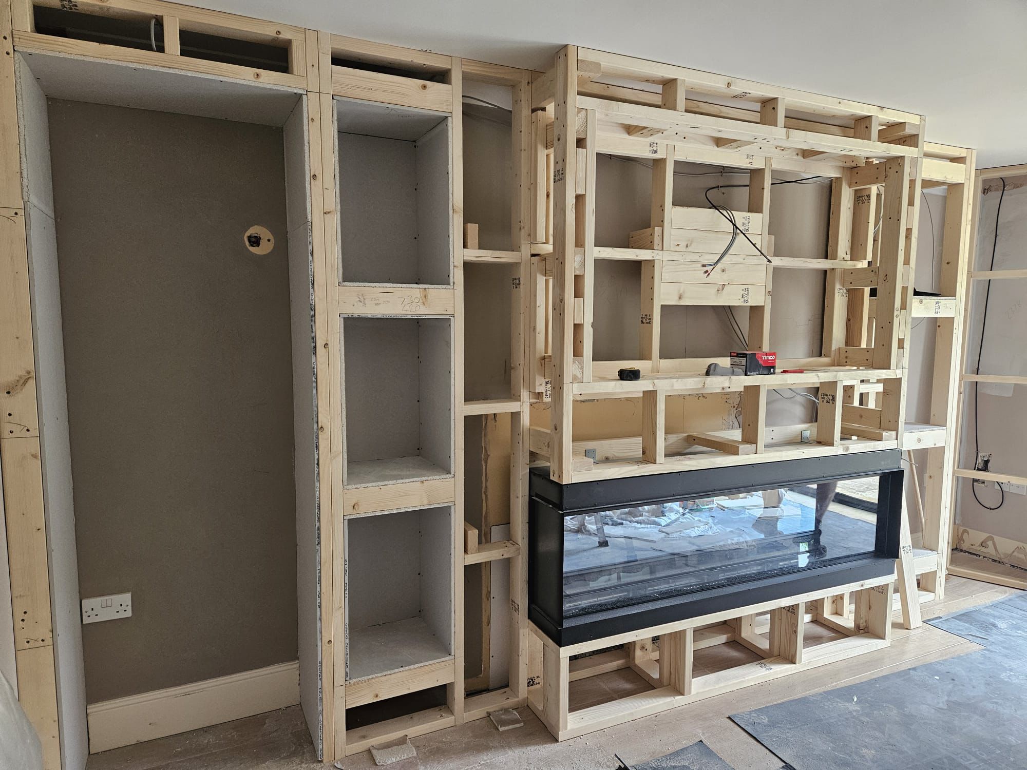 Timber stud framework for a media wall built around a fireplace