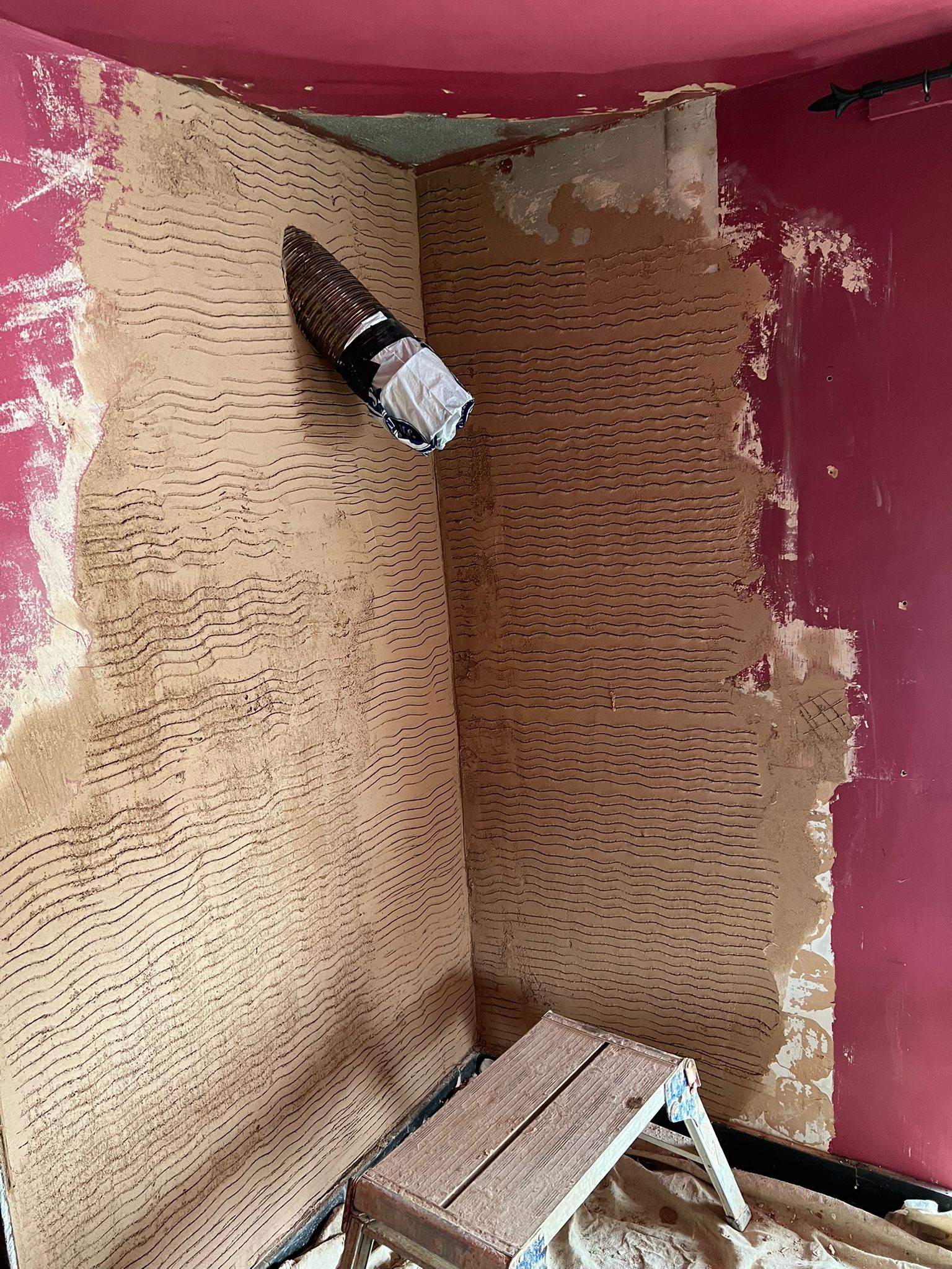 Scratch coat being applied to chimney breast alcove