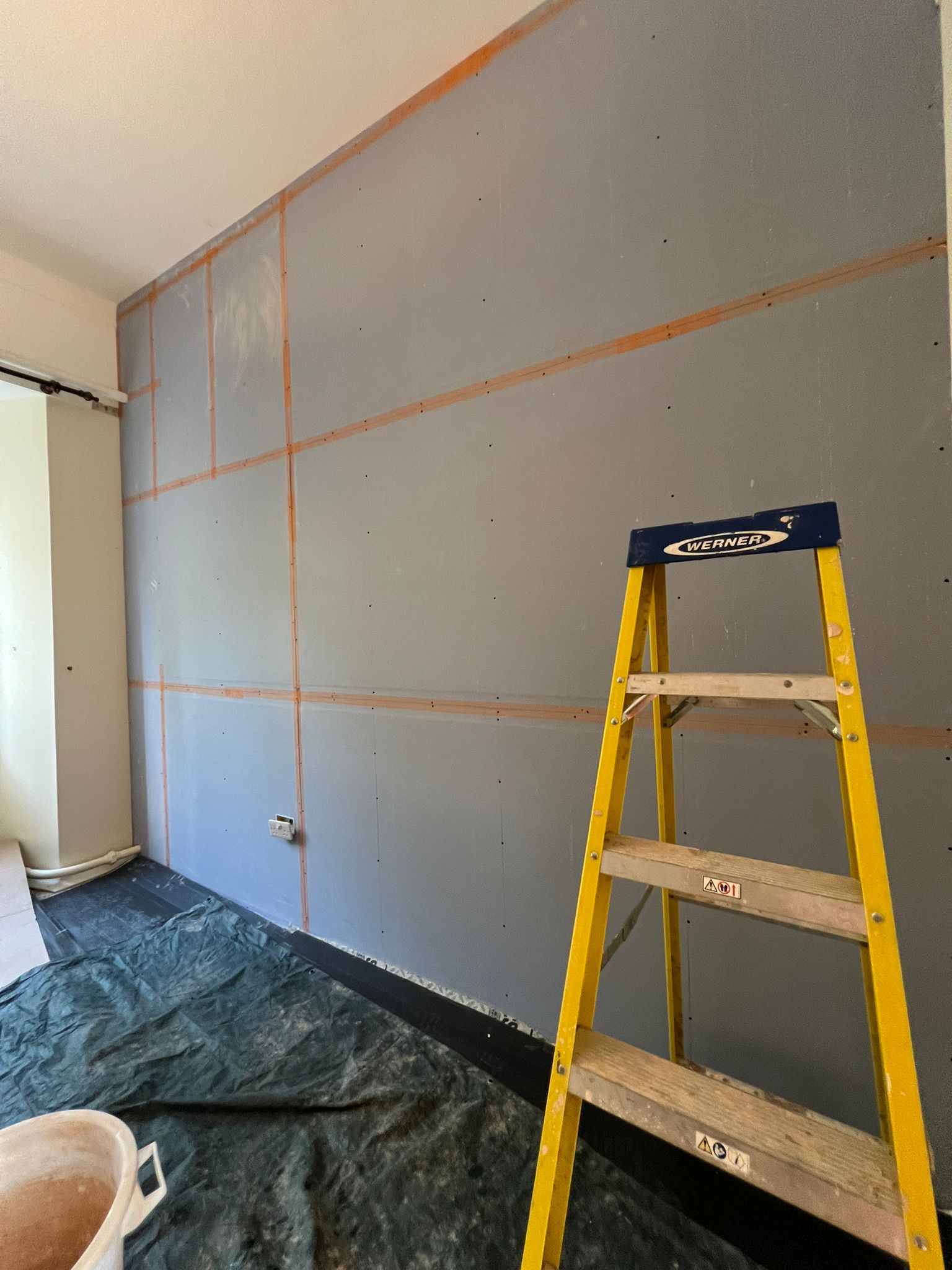 Dot-and-dab overboarding on interior wall with taped joints