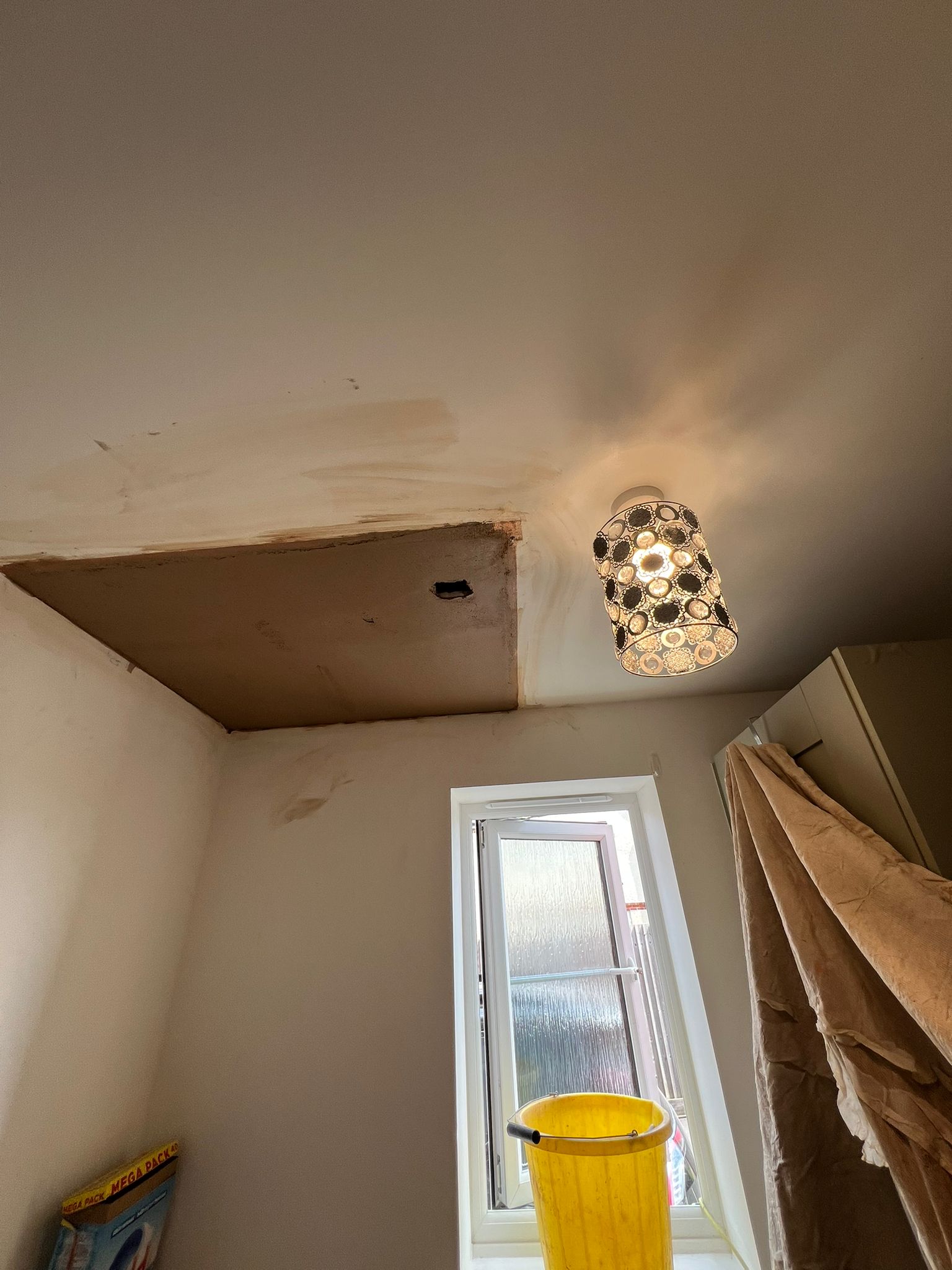 Ceiling patch repair — wider angle showing finished surround