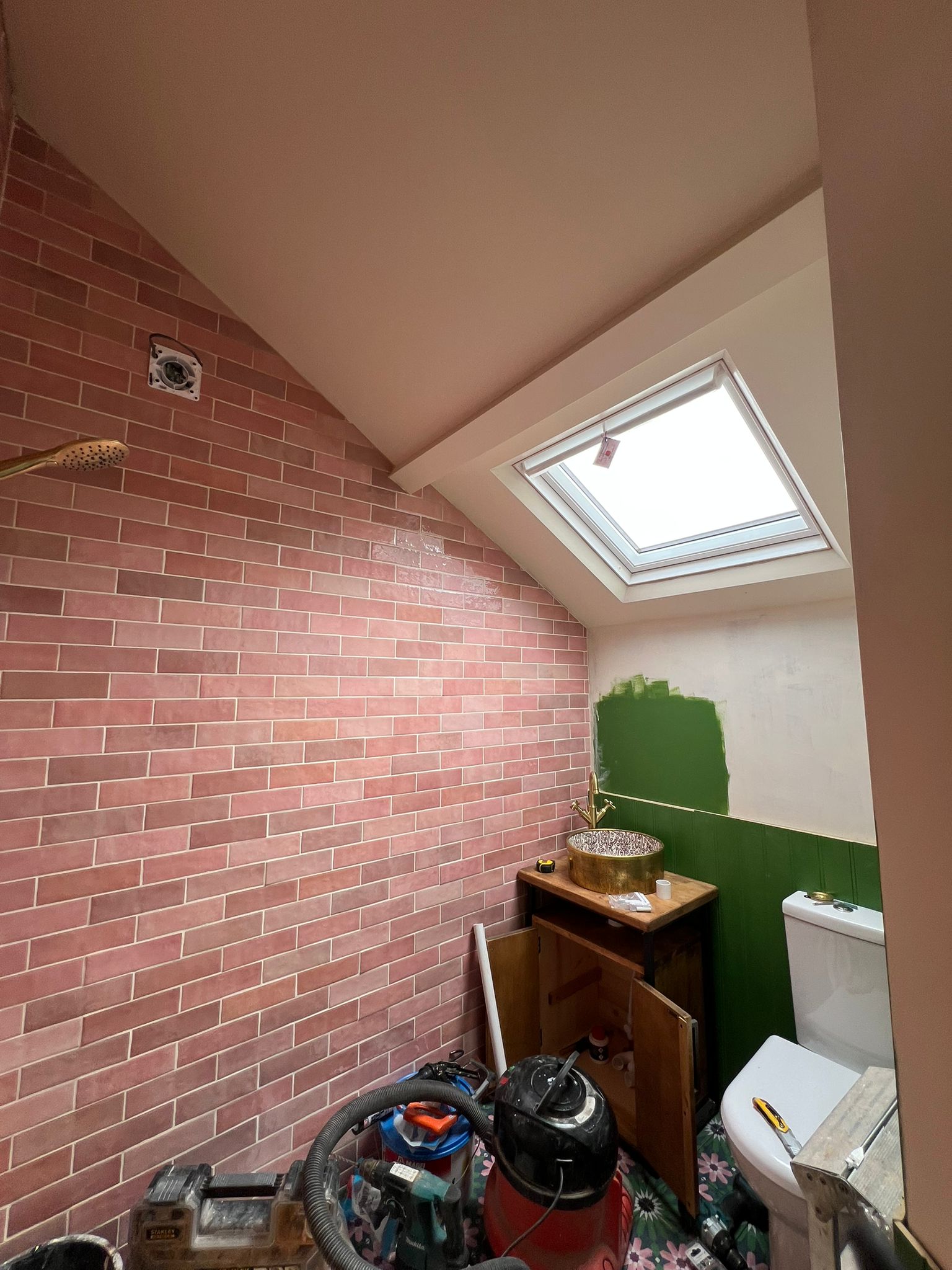 Loft bathroom wider view with tiled shower wall and plastered ceiling