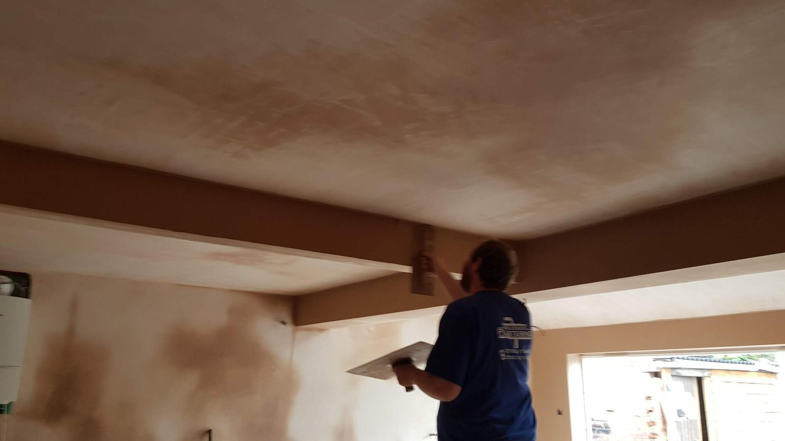 Plasterer skimming a beam in kitchen extension