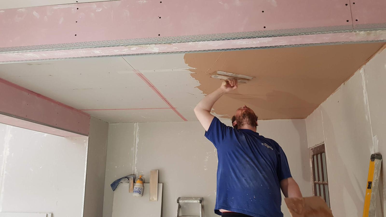 Plasterer skimming plasterboard ceiling