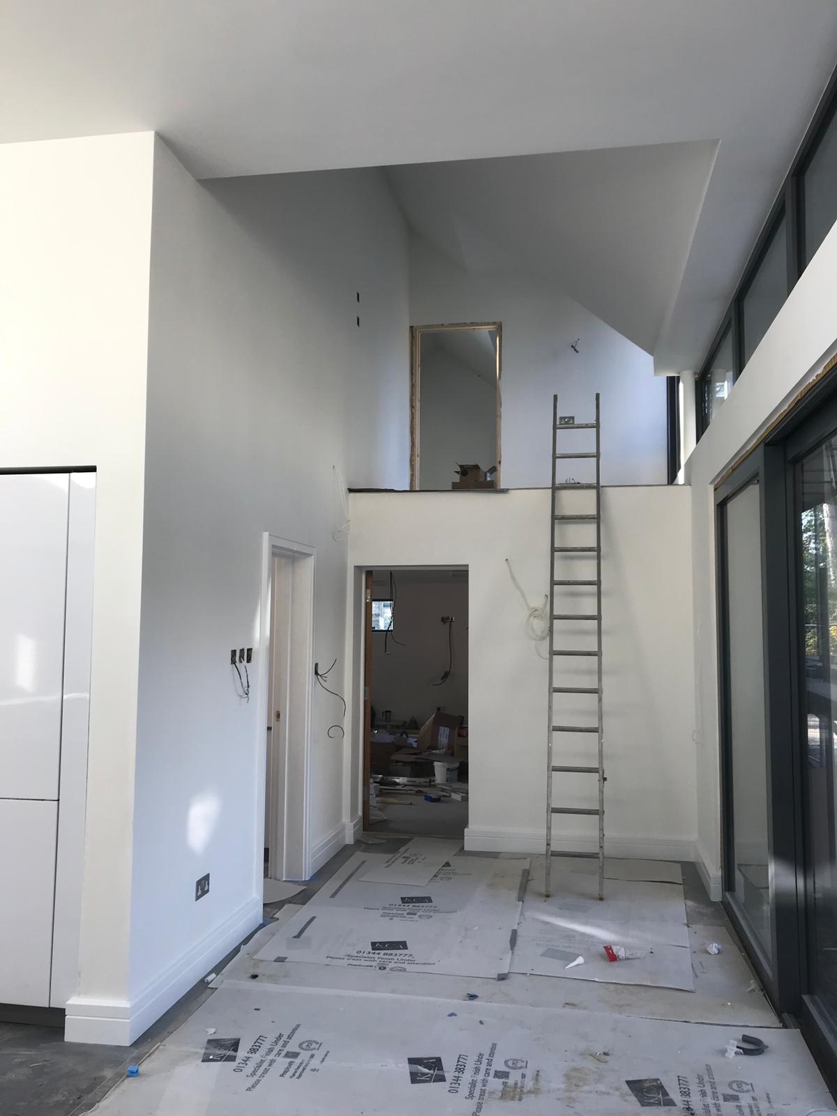 Double-height new build interior with vaulted ceiling, freshly plastered
